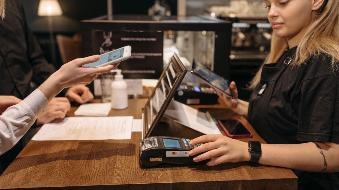 Client payant par mobile sans contact au comptoir d'un café, méthode similaire pour paris sportifs