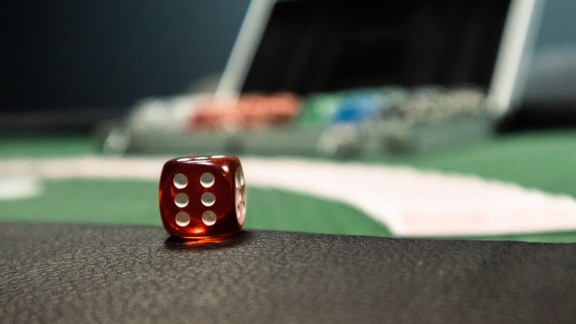 Dé rouge en gros plan sur un tapis de table de casino