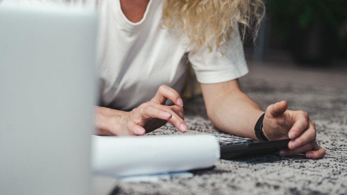 Femme calculant son budget de jeu avec une calculatrice sur un tapis