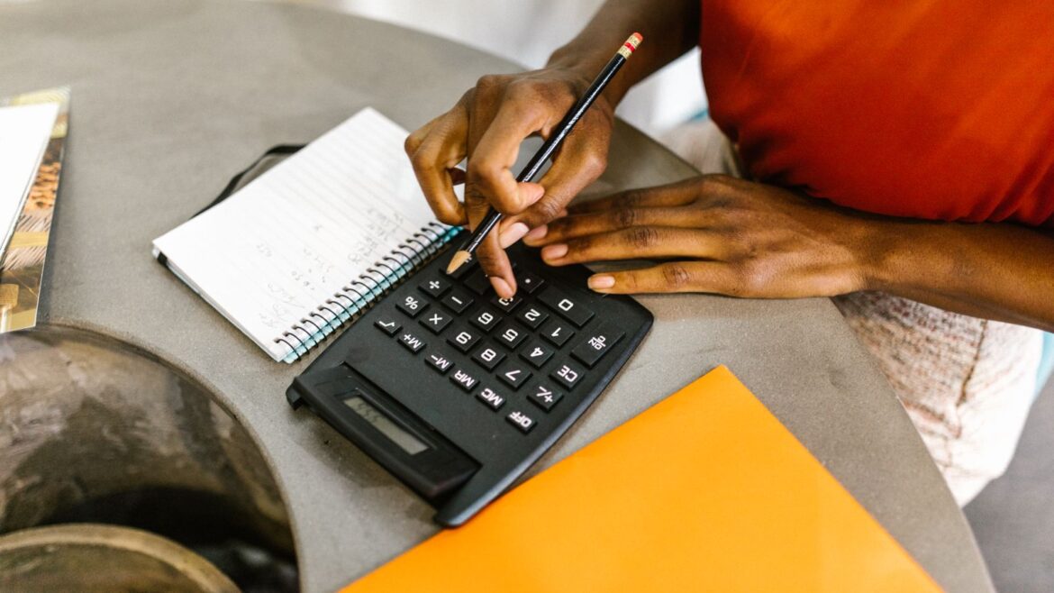 Femme utilisant une calculatrice et un carnet pour gérer son budget de jeu