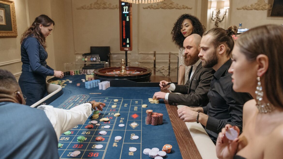 Groupe de personnes autour d'une table de roulette dans un casino luxueux