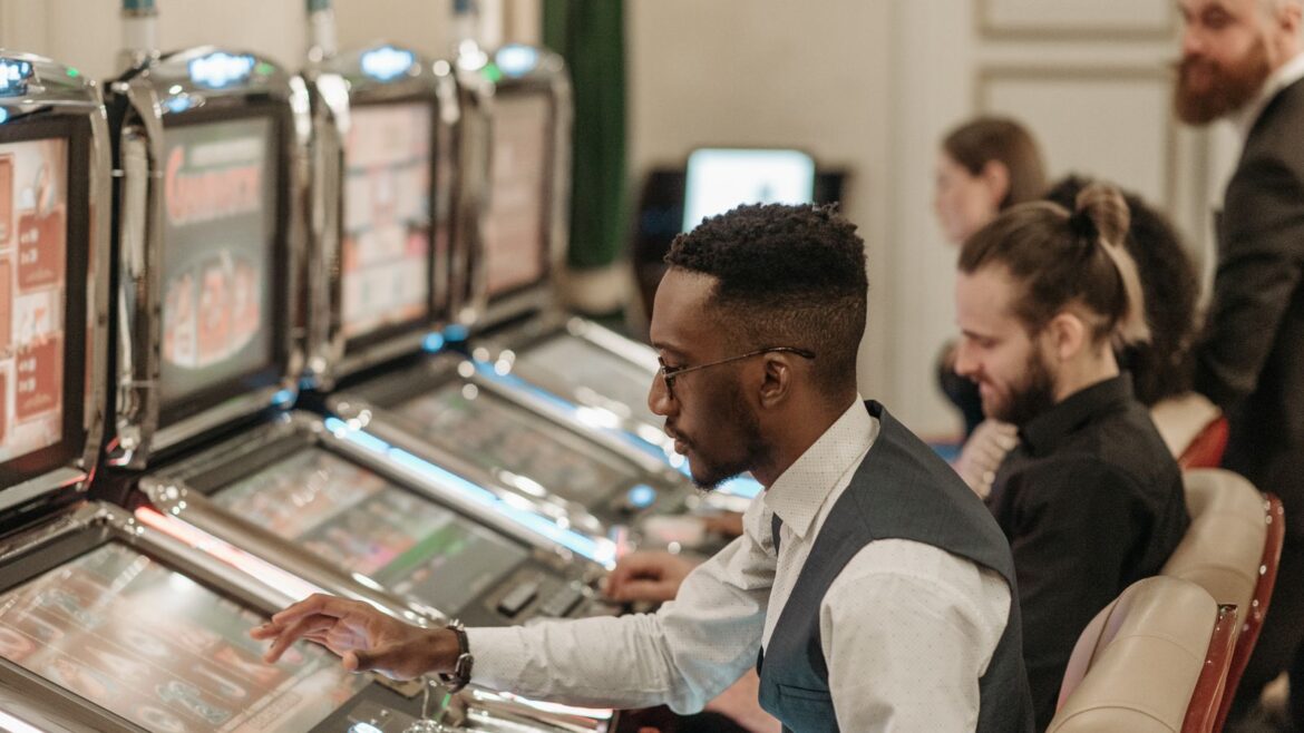 Groupe d'hommes jouant aux machines à sous dans un casino le soir