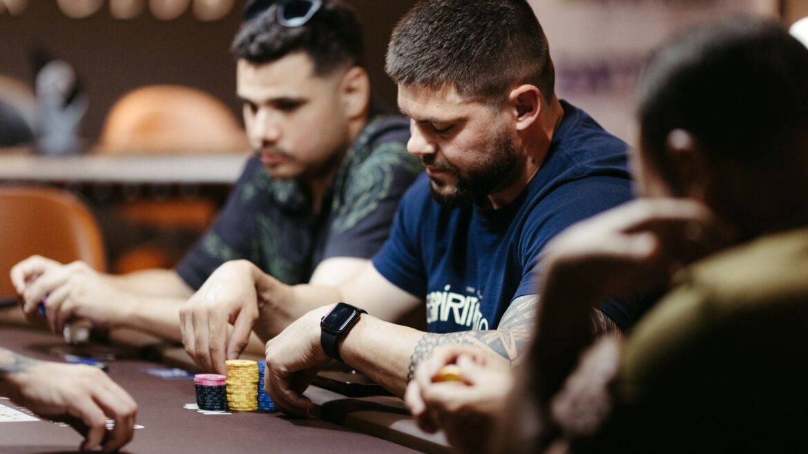 Joueurs concentrés autour d'une table de poker en casino, cartes et jetons visibles