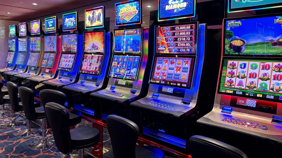 Machines à sous colorées et lumineuses alignées dans une salle de casino vide