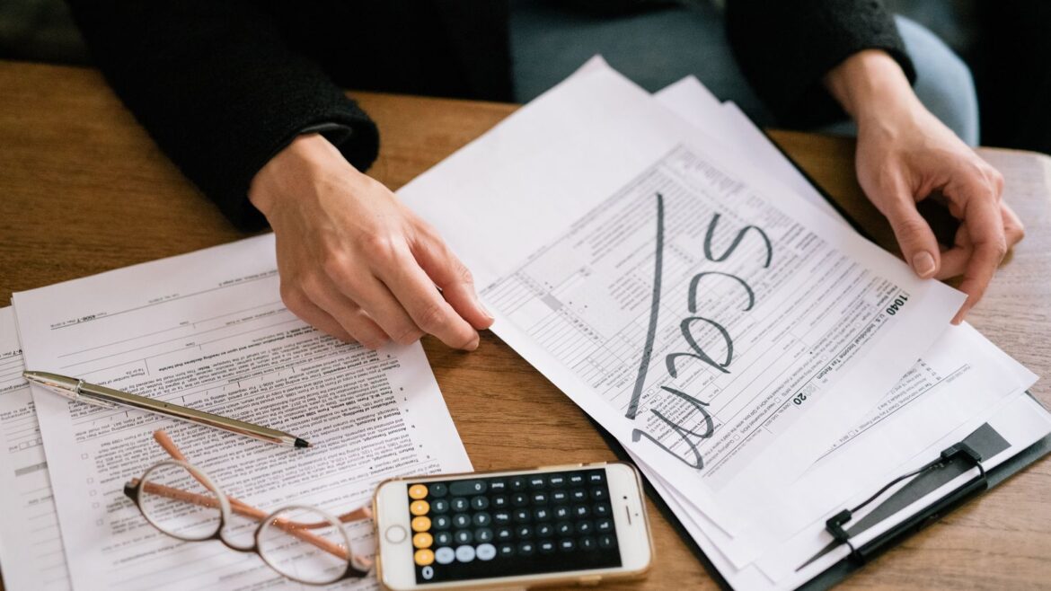 Mains examinant des documents et une calculatrice pour vérifier les conditions de mise d'un bonus
