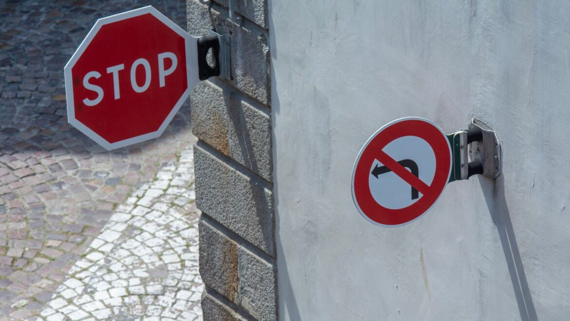 Panneaux stop et sens interdit en gros plan sur un mur de rue
