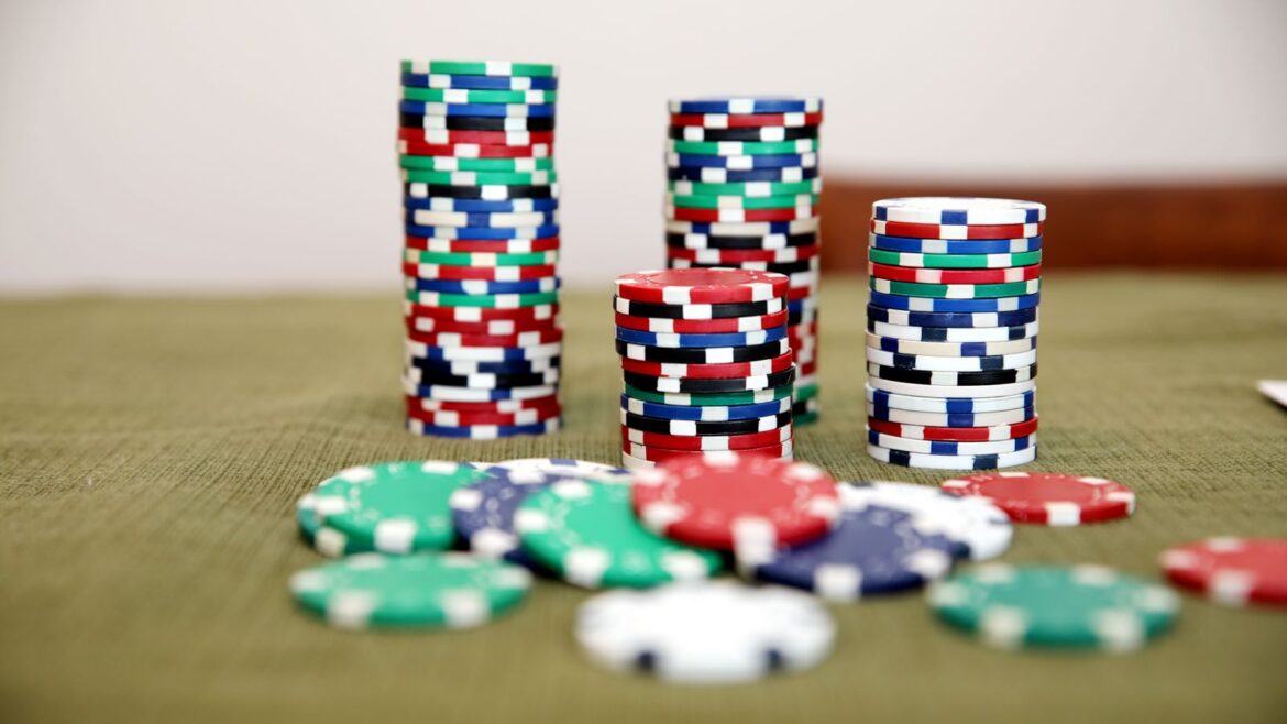 Piles de jetons de poker colorés sur un tapis vert de casino