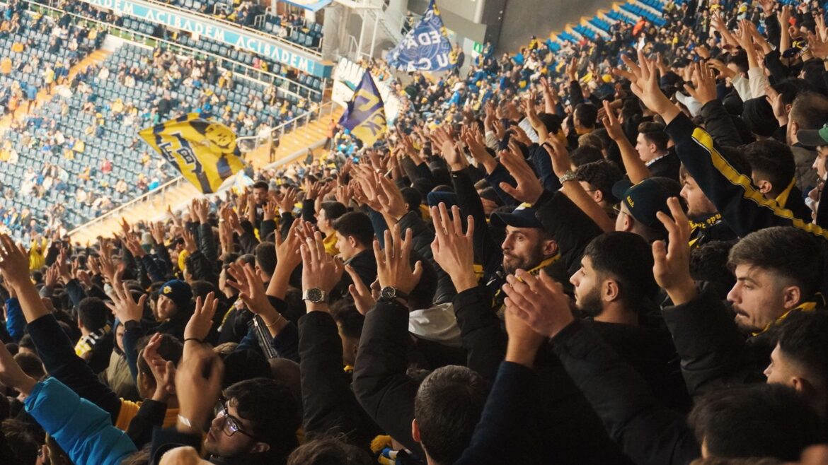 Supporters levant les mains dans un stade lors d'un match de football